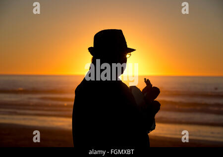 a man plays guitar on the beach at sunset, La Jolla, California, USA Stock Photo