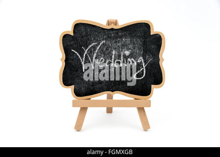 Wooden easel mini blackboard with faded chalk surface and text WEDDING, front view, isolated on white, with clipping path, copy Stock Photo