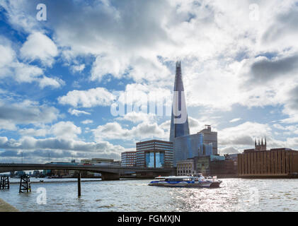 View over River Thames to London Bridge with The Shard behind and MBNA Thames Clipper in foreground, London, England, UK Stock Photo