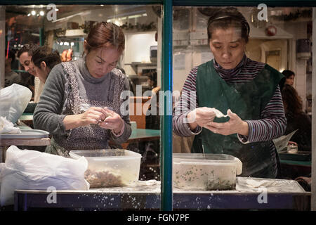 Two women making Chinese dumplings in the window of a restaurant Stock Photo