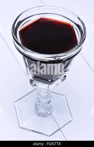 Glass of red wine on a white wooden board Stock Photo