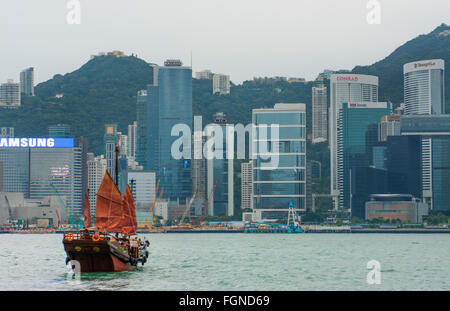 Hong Kong China skyline from water with traditional junk boat against city background Stock Photo