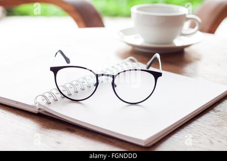 Open blank white notebook and eyeglasses with cup of coffee, stock photo Stock Photo