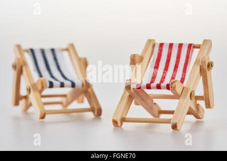 Red and blue miniature figurine deckchairs isolated closeup Stock Photo