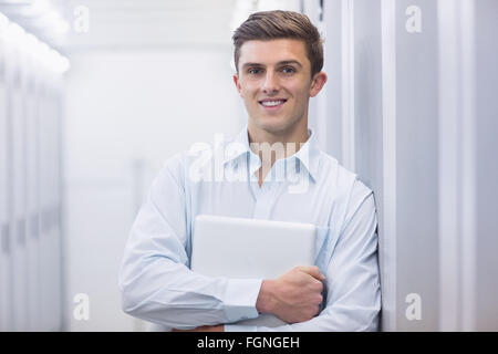 Portrait of a smiling technician holding a laptop Stock Photo