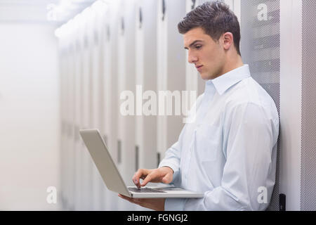 Focused technician typing on his notebook Stock Photo