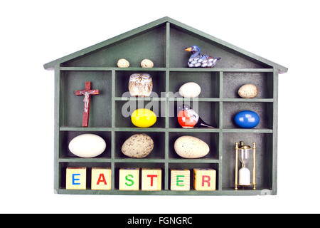 Partitioned wooden shelf filled with objects in connection with Easter holiday isolated on white background Stock Photo