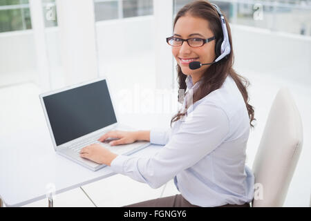 Smiling businesswoman using laptop at her desk Stock Photo