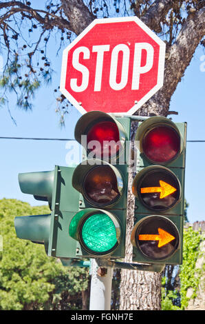 Road sign "stop" and traffic lights at the crossroads on sunny day with two orange pointers Stock Photo