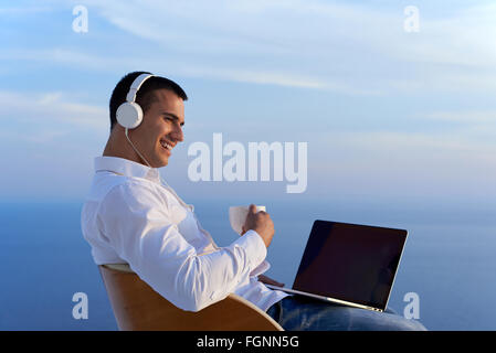 relaxed young man at home on balcony Stock Photo