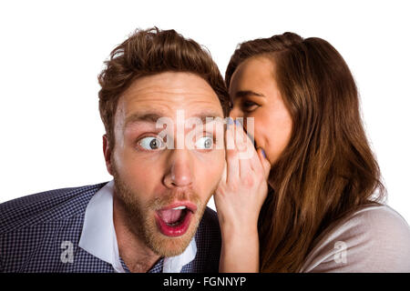 Woman whispering secret into friends ear Stock Photo