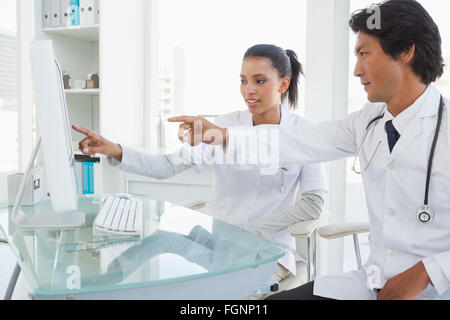 Two doctors pointing to computer screen Stock Photo