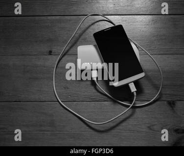 Smartphone and powerbank on wooden background Stock Photo