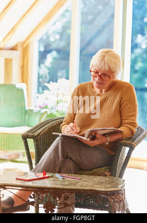 Senior woman coloring in coloring book Stock Photo