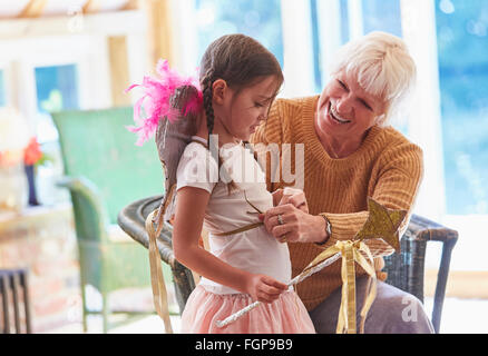 Grandmother fitting granddaughter with wings Stock Photo