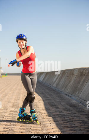 Carefree sporty blonde posing with inline skates Stock Photo