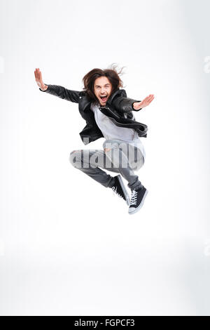 Handsome excited young man jumping and screaming over white background Stock Photo