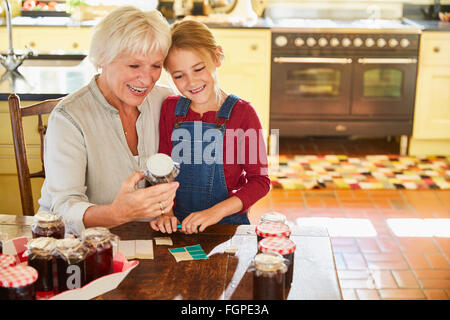 Grandmother and granddaughter canning jam in kitchen Stock Photo