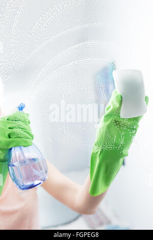 Woman cleaning window pane with detergent, cleaning concept Stock Photo