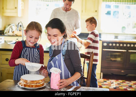 Family baking cake in kitchen Stock Photo