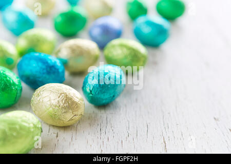 Close up of an assortment of chocolate Easter eggs on a rustic wooden background. Stock Photo