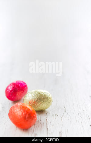 Close up of an assortment of chocolate Easter eggs on a rustic wooden background. Stock Photo