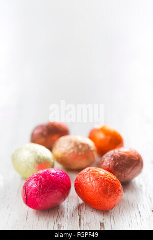 Close up of an assortment of chocolate Easter eggs on a rustic wooden background. Stock Photo