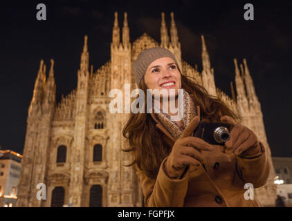 It is time to dress up and take a night tour in ultra-luxurious fashion expert - Milan, Italy. Smiling young woman with digital Stock Photo