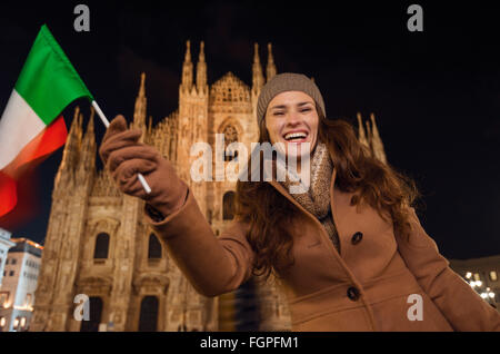 It is time to dress up and take a night tour in ultra-luxurious fashion expert - Milan, Italy. Portrait of smiling young woman w Stock Photo