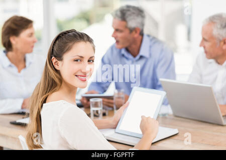 Smiling businesswoman with tablet in a meeting Stock Photo
