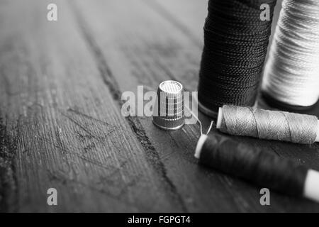 white and black thread with sewing needle Stock Photo - Alamy