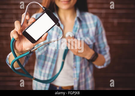 Pretty hipster using her smartphone to diagnose Stock Photo