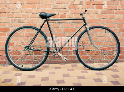Retro style bicycle against brick wall, vintage tinted photo Stock Photo