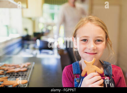 Portrait smiling girl eating gingerbread cookie Stock Photo