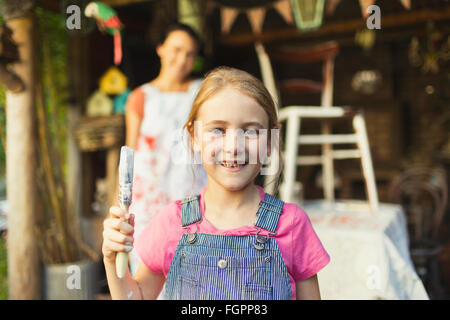 Portrait smiling girl holding paintbrush Stock Photo