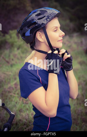 Athletic blonde putting on helmet Stock Photo - Alamy