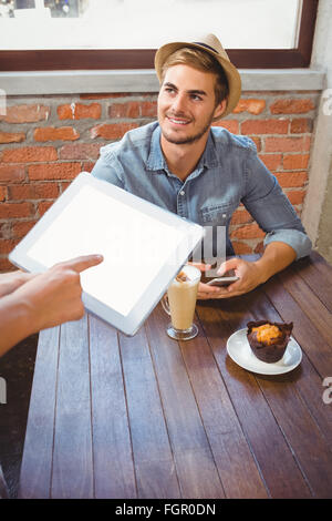 Waitress taking handsome hipsters order with tablet Stock Photo