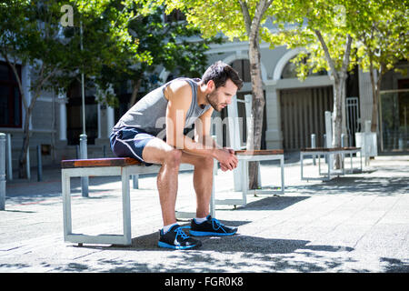 Exhausted athlete resting on a bench Stock Photo