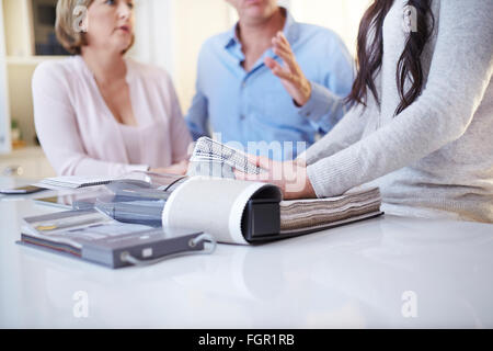 Interior designer discussing swatches with couple in consultation Stock Photo