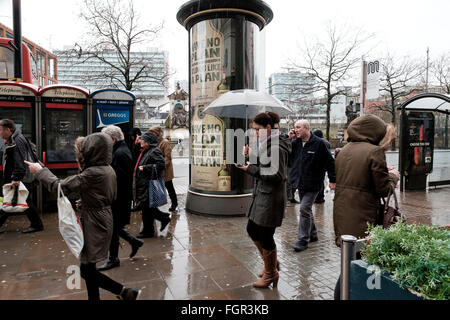 Manchester, UK - 17 February 2016: Raining on Piccadilly Gardens Manchester with people hurrying by Stock Photo