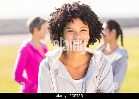 Smiling sporty woman in front of friends Stock Photo