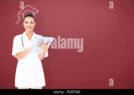 Composite image of pretty nurse using tablet pc Stock Photo
