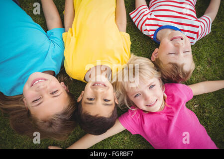 Smiling classmates lying in grass Stock Photo