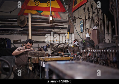 Blacksmith working in forge Stock Photo