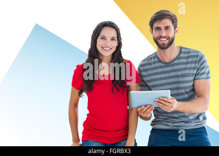 Composite image of couple posing with tablet Stock Photo