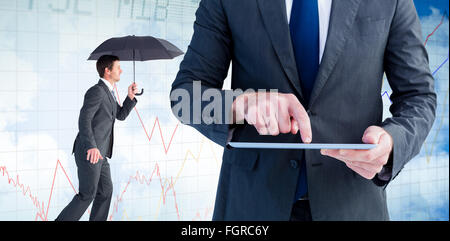 Composite image of businessman sheltering under black umbrella Stock Photo