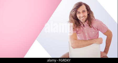 Composite image of portrait of hipster smiling while sitting on chair Stock Photo