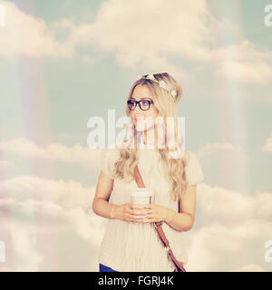 Composite image of gorgeous blonde hipster leaning against red brick background Stock Photo