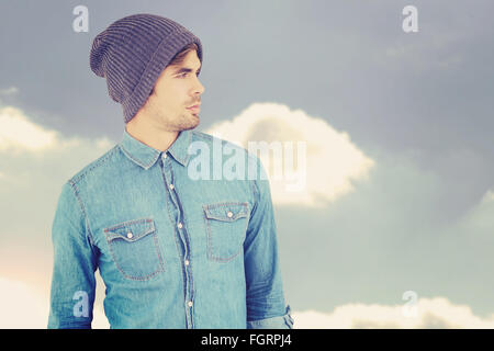Composite image of confident hipster wearing knitted hat Stock Photo
