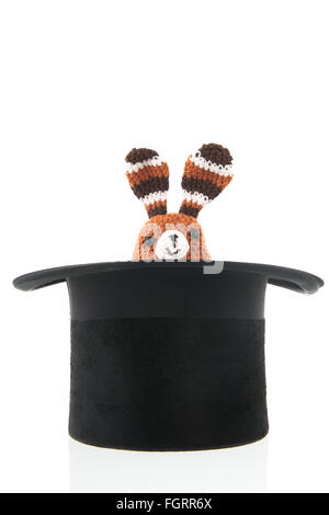Hand made funny little stuffed toy rabbit in black hat Stock Photo